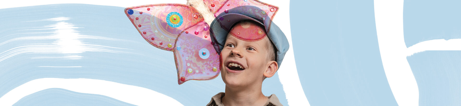 Sonimütsiga poiss imetlemas suurt värvilist liblikat